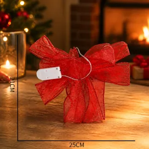 Detail view of red glowing Christmas bow with LED lights and battery box in packaging