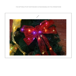 Close-up of LED glowing Christmas ribbon bow with gold edges and festive lights