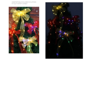Detail of LED Christmas ribbon bow showing glowing lights on mesh fabric for tree decor