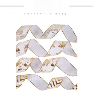 Close-up of four festive white ribbons with various gold metallic Christmas patterns