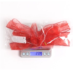 Detail of red mesh Christmas bow with built-in LED string lights and battery box