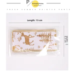 Close-up of white festive ribbon featuring golden reindeer and pine forest patterns