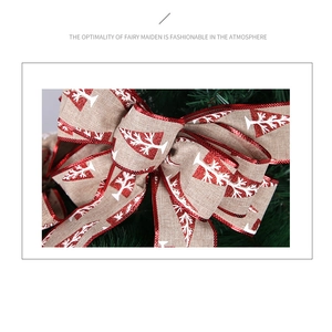 Macro detail of burlap Christmas bow with red glitter edges and white tree pattern