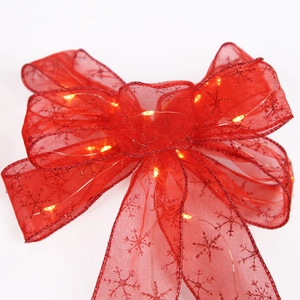 Red sheer mesh Christmas bow with sparkling snowflake patterns and warm yellow LED lights