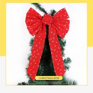 Detail of red Christmas velvet bow with gold star sequins on a green holiday tree