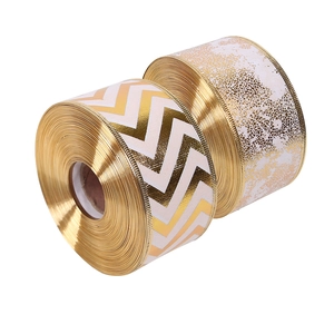 Two rolls of white and gold Christmas ribbons with decorative wavy and marble textures