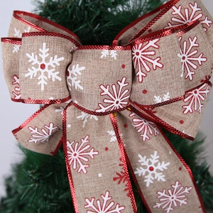 European faux linen Christmas bow with red snowflake patterns on a holiday tree top