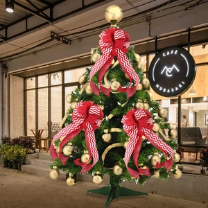 Three red and white striped bow decorations displayed on a Christmas tree