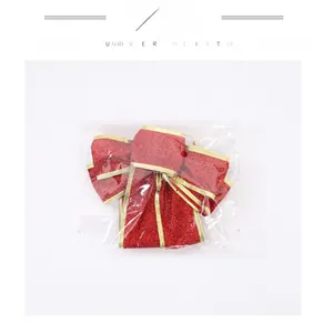 Close-up of red Christmas bow with gold glitter edges in transparent plastic packaging