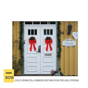 Detail of red velvet Christmas bows with gold glitter on a green festive wreath