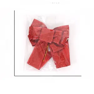Detail view of a 26x22cm red glitter Christmas bow ornament with size markers