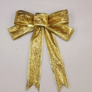 Glittering gold Christmas bow ornament for holiday tree decoration on grey background