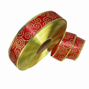 Dettaglio del nastro natalizio in raso rosso con spirali glitterate dorate e bordo metallico