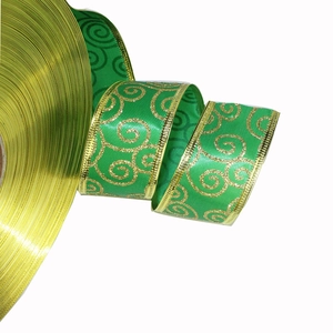 Dettaglio del nastro natalizio verde con motivi a spirale dorati e bordi in metallo