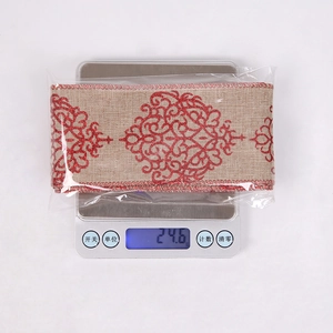 Macro detail of red glitter pattern on natural jute ribbon material for Christmas DIY craft