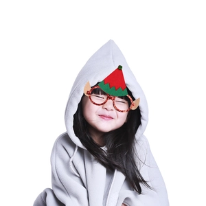 Close-up of glittery Christmas elf glasses with green ears and a red pompom hat