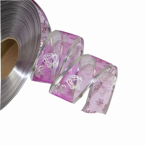 Detail of sheer purple Christmas ribbon with silver snowflake prints and woven edges