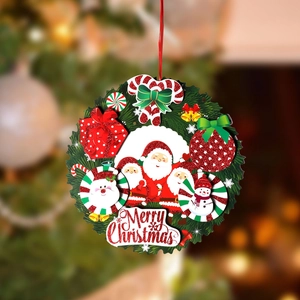 Detail of a Merry Christmas wreath ornament with Santa and snowman on a festive tree