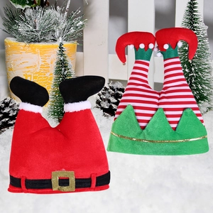 Detailed plush Christmas elf and Santa leg ornaments on a snowy holiday scene background