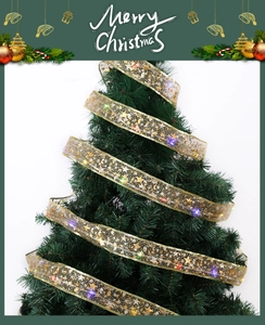 Close-up of champagne gold LED ribbon with star and moon patterns on a Christmas tree