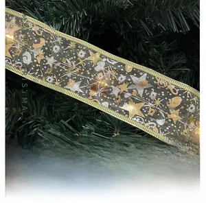 Detail of champagne LED ribbon with gold star patterns and Merry Christmas text