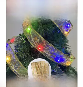 Detail of golden mesh Christmas ribbon with multicolor LED lights wrapped on a tree