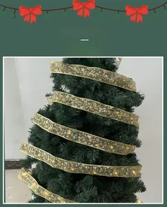 Detail of gold Christmas ribbon with LED lights and star pattern on a green tree