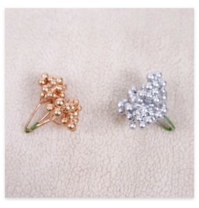 Close-up of metallic rose gold and silver artificial Christmas berry stems for DIY wreaths