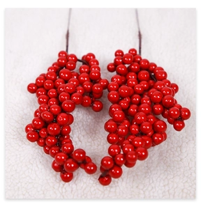 Macro shot of two glossy red artificial berry stems for Christmas DIY floral decoration