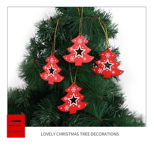 Close-up of red wooden Christmas tree ornaments with white snowflake patterns on branches