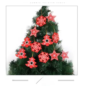 Detail of red wooden Christmas ornaments with white snowflake and star patterns