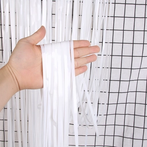 Close-up of white macaron fringe curtain showing soft texture for party backdrop