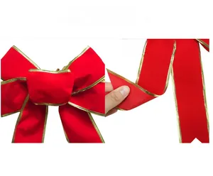 Detail of red velvet Christmas bow with gold metallic wire edges for festive tree decoration