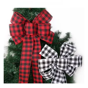 Detail of red and black checkered polyester bows hanging on a green Christmas tree branch