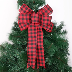 Red and black buffalo plaid Christmas bow ornament hanging on a lush green pine tree