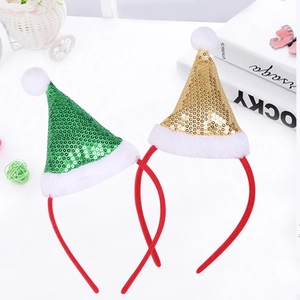 Detail of Christmas headbands with festive gold and green sequin hats on white table