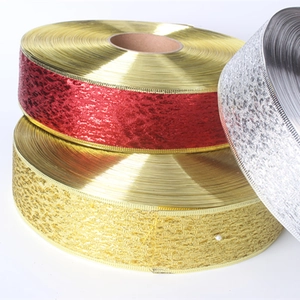 Detail of metallic glitter ribbons in gold, red and silver with fine woven texture