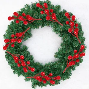 Close-up of artificial red berries and pine needle wreath for Christmas DIY crafts