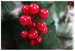 Gros plan macro de baies artificielles rouges brillantes sur des aiguilles de pin pour Noël