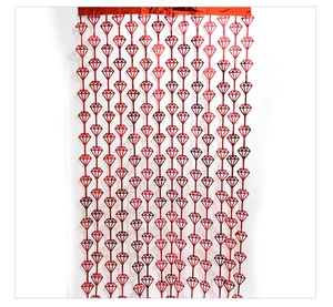 Detail of red metallic fringe curtain with diamond cutout patterns for party backdrop