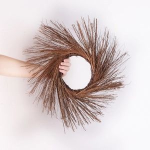 Natural brown vine wreath for Halloween party decor held by hand against white background