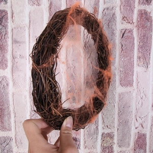 Halloween wreath with dried brown vines and bright orange spider web decor for party