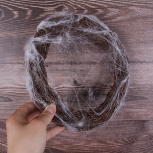 Macro detail of Halloween vine wreath decorated with realistic white faux spider webs