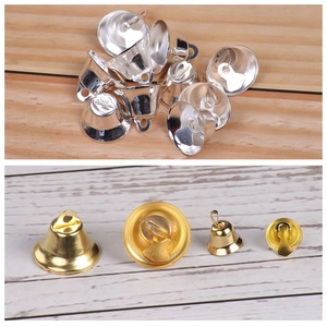 Macro detail of small gold and silver Christmas bells showing metal texture and top hanging loops