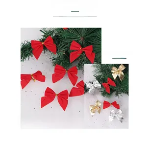 Macro detail of velvet red gold and silver mini Christmas bows on a decorative pine branch