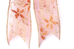 Macro detail of pink sheer Christmas ribbon with gold glitter Christmas Greetings text