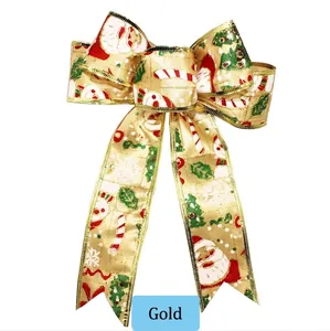Detalle de lazo navideño dorado de 20 cm con motivos de Papá Noel y muñeco de nieve