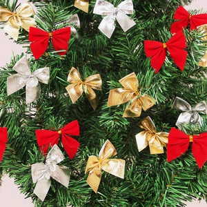 Detail of red flocked and metallic gold silver Christmas bows on a green pine tree