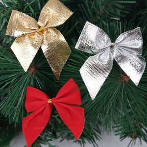 Christmas bow set with red flocked, gold, and silver metallic bows on green pine needles