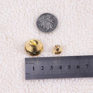 Detailed size comparison of small gold bells for Christmas wreaths and DIY crafts